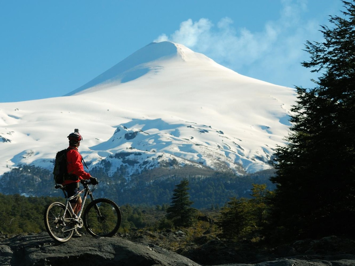 Cyclist looking at snowy mountains