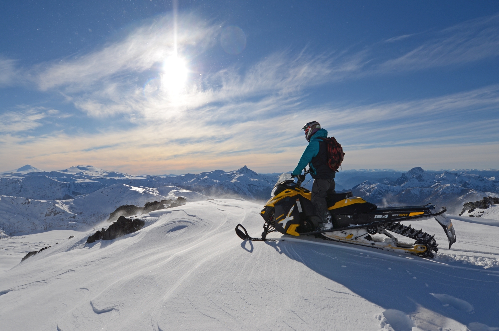 person on snowmobile looking over the mountains