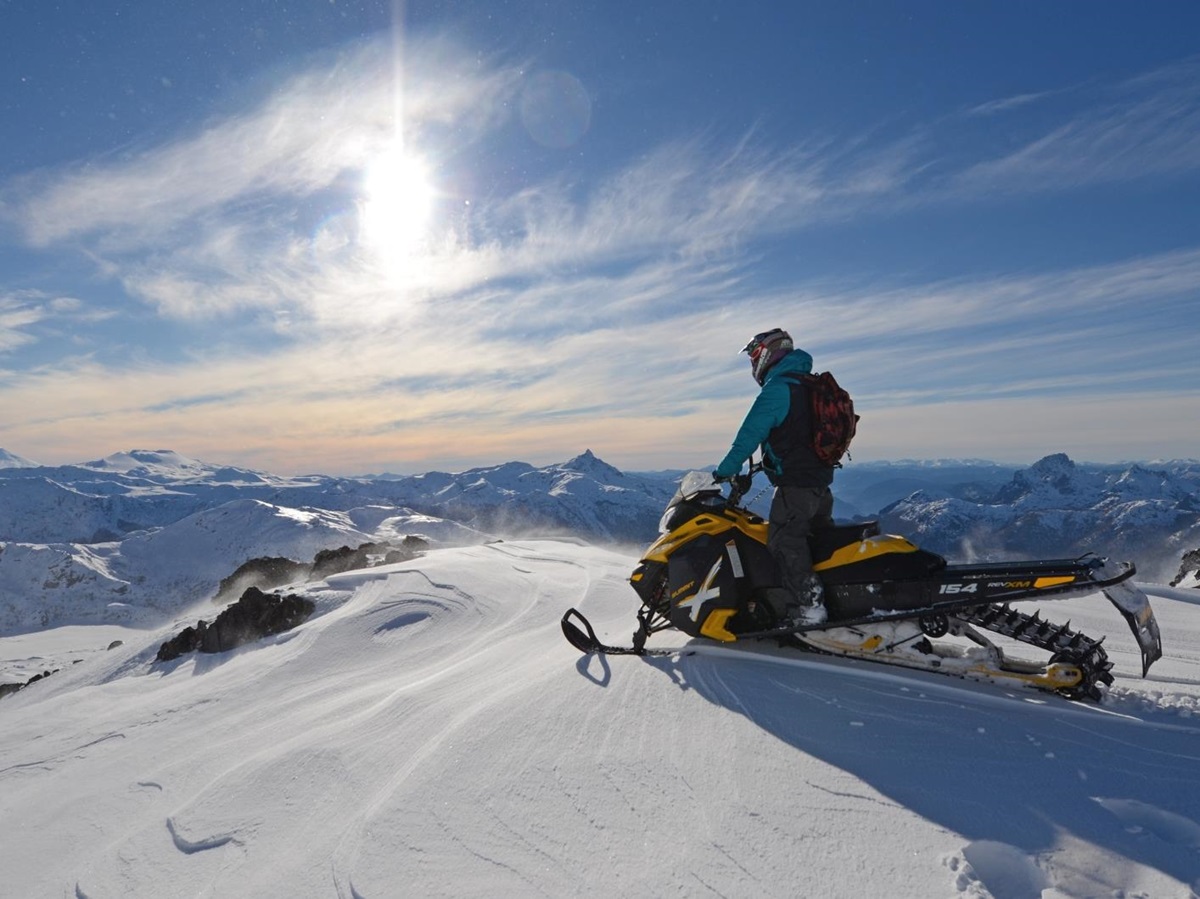 person on snowmobile looking over the mountains