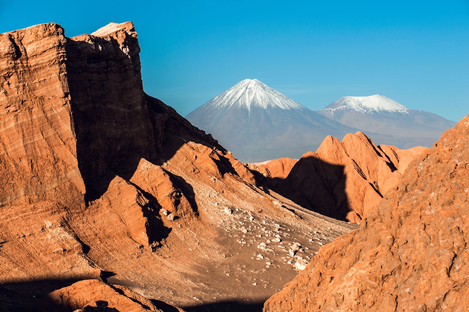View of the Moon Valley and snow-capped volcanoes in the Atacama, Chile