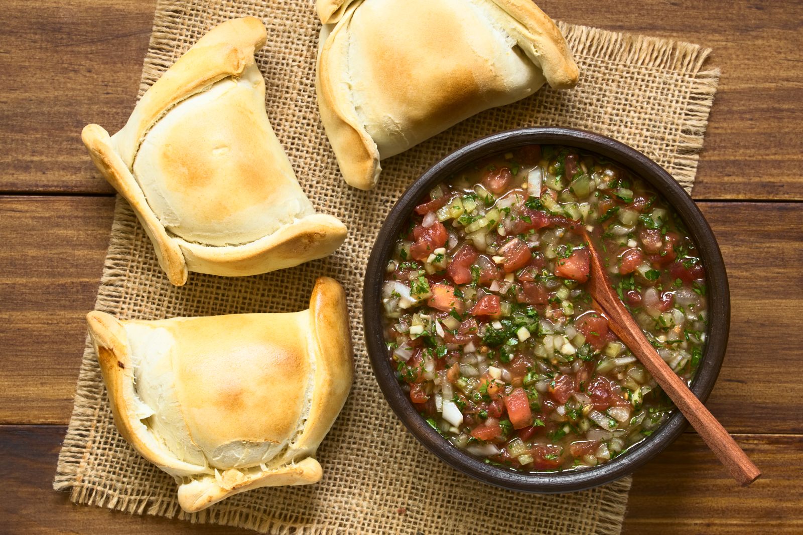Freshly baked empanadas and typical pebre sauce in Chile