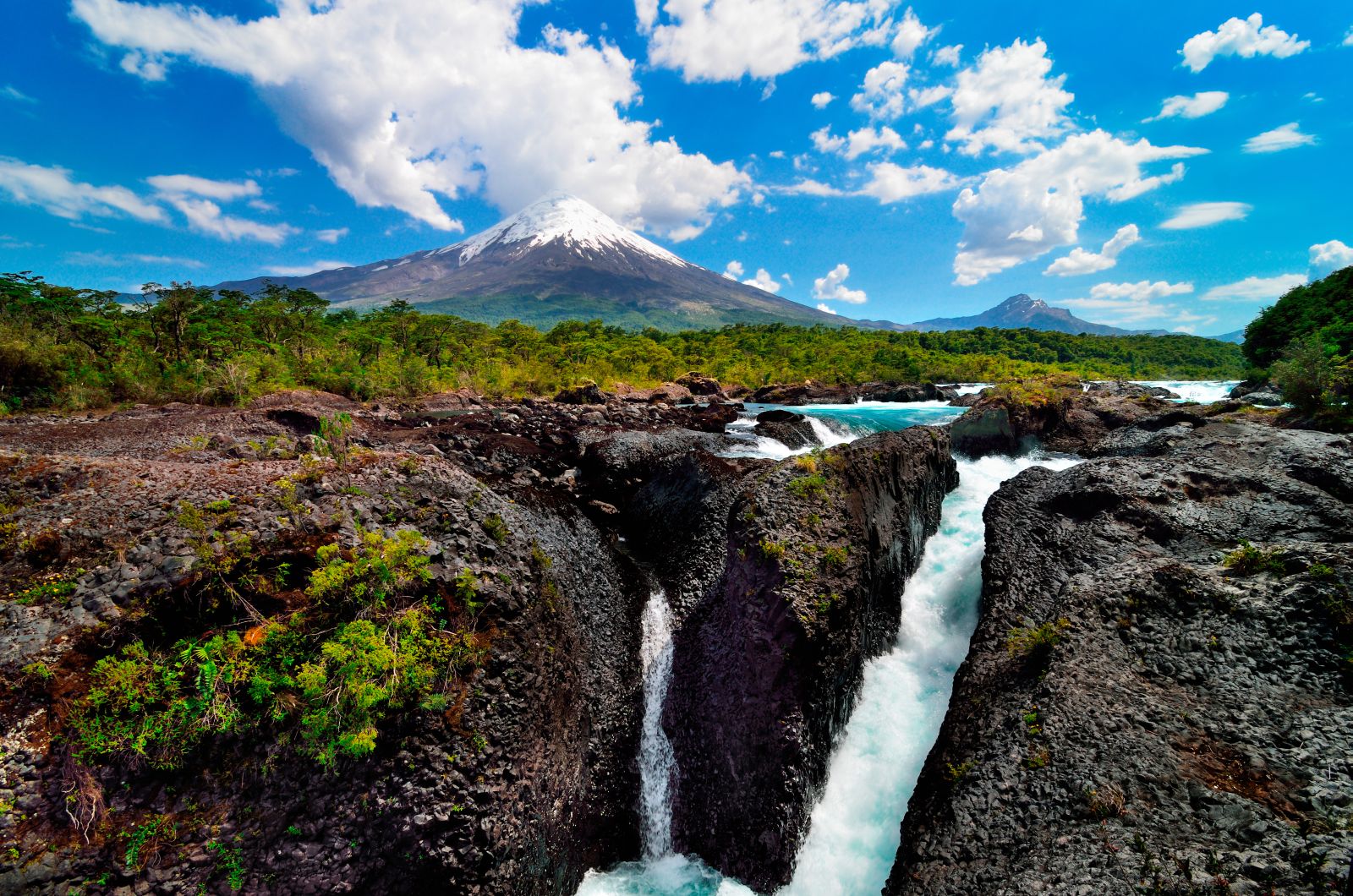 Plunging waterfall in front of a volcano