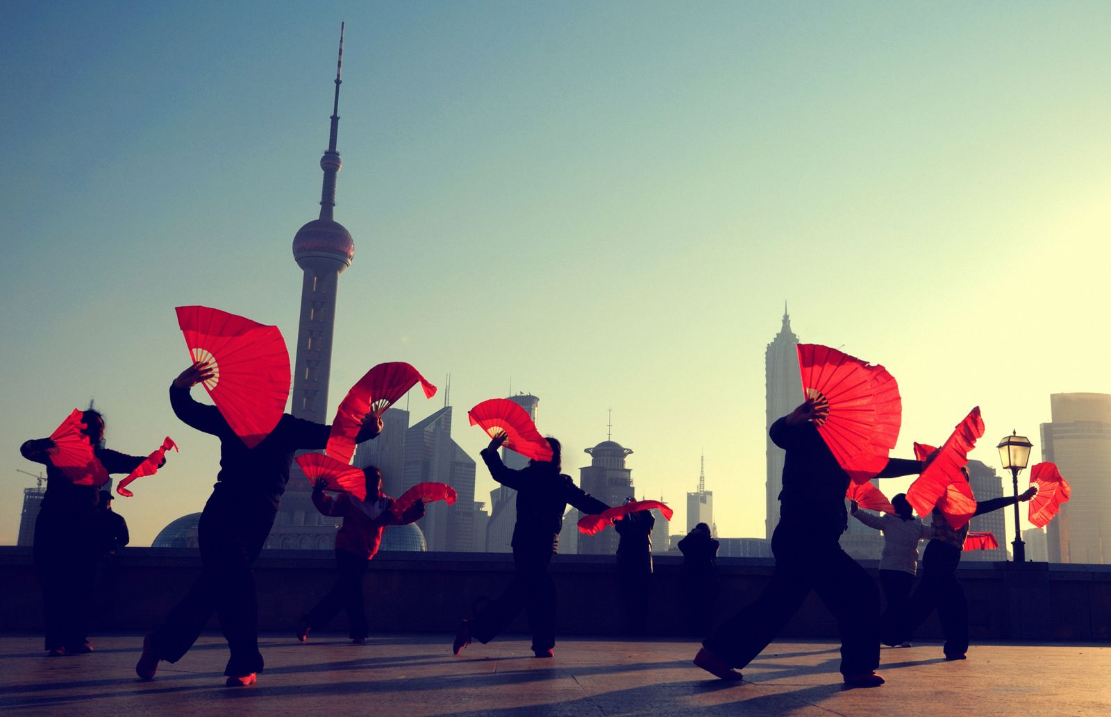 Traditional fan dancers against the Shanghai skyline in China