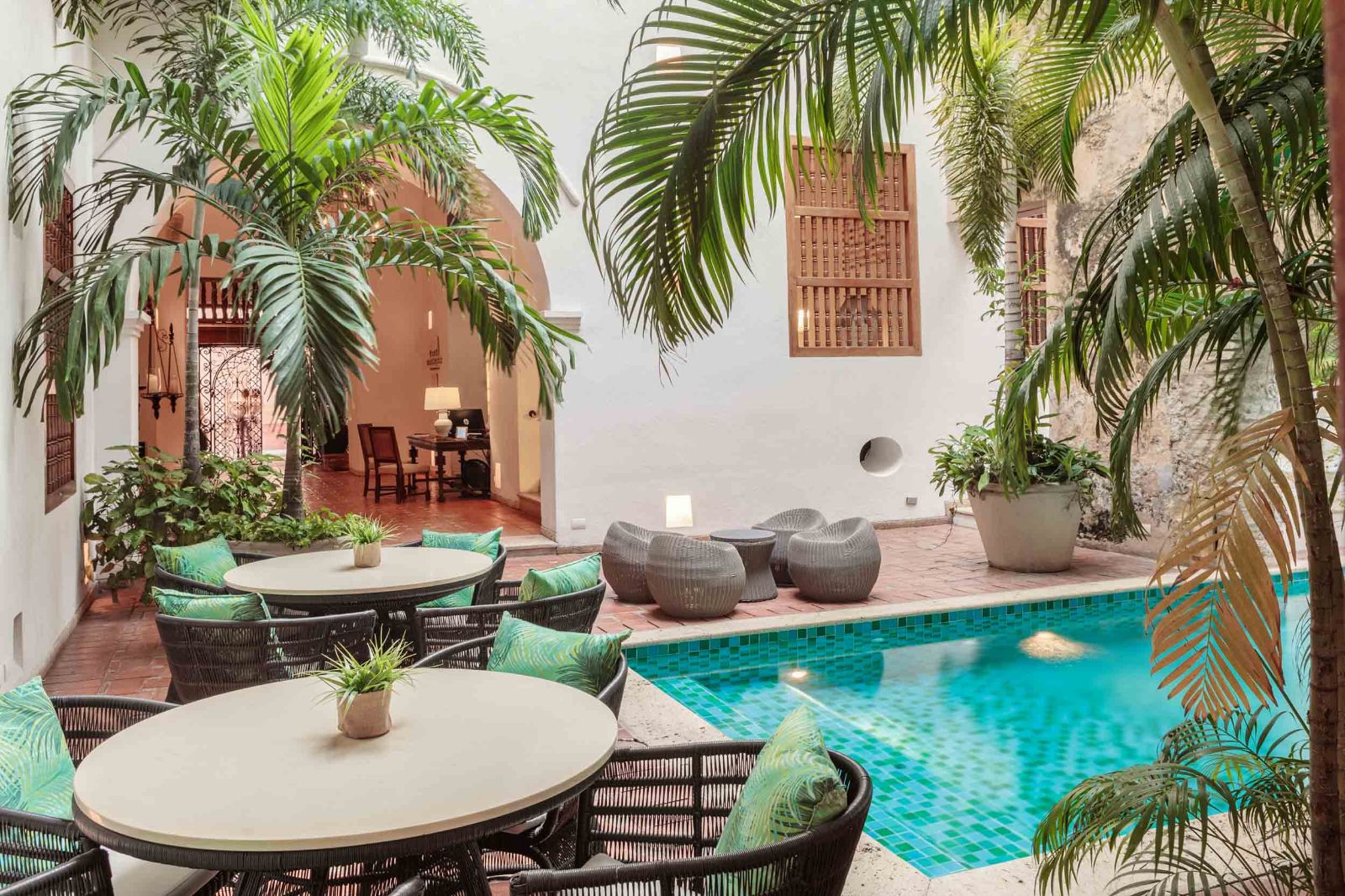 Pool and small dining tables at Casa San Agustin in Cartagena, Colombia