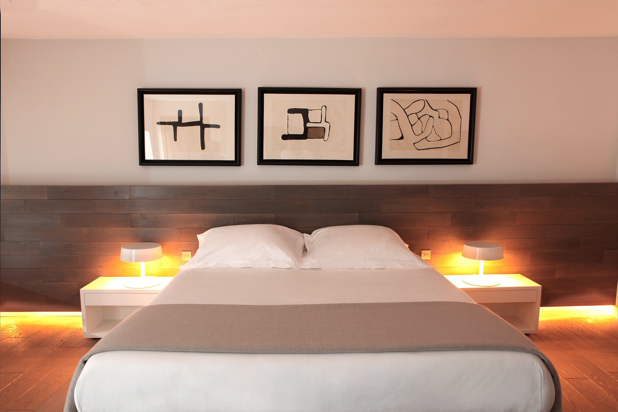 bed with three pictures hanging on the wall at Hotel U Palazzu Serenu in Corxica, France