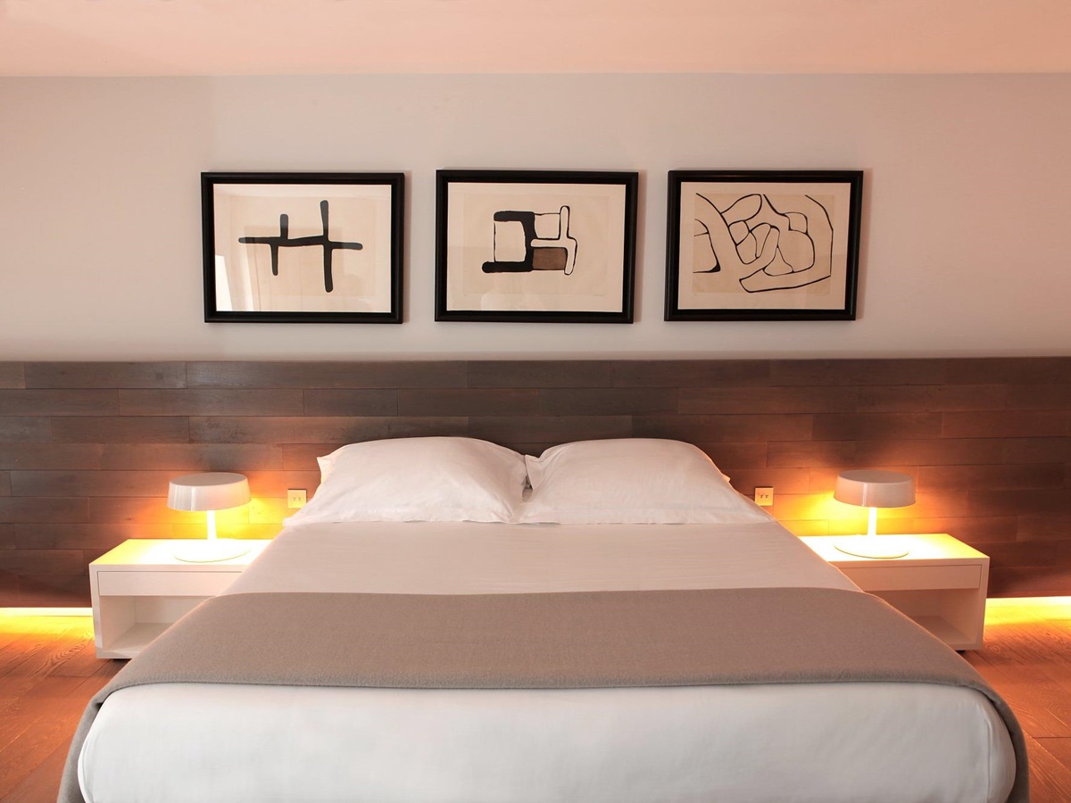 bed with three pictures hanging on the wall at Hotel U Palazzu Serenu in Corxica, France