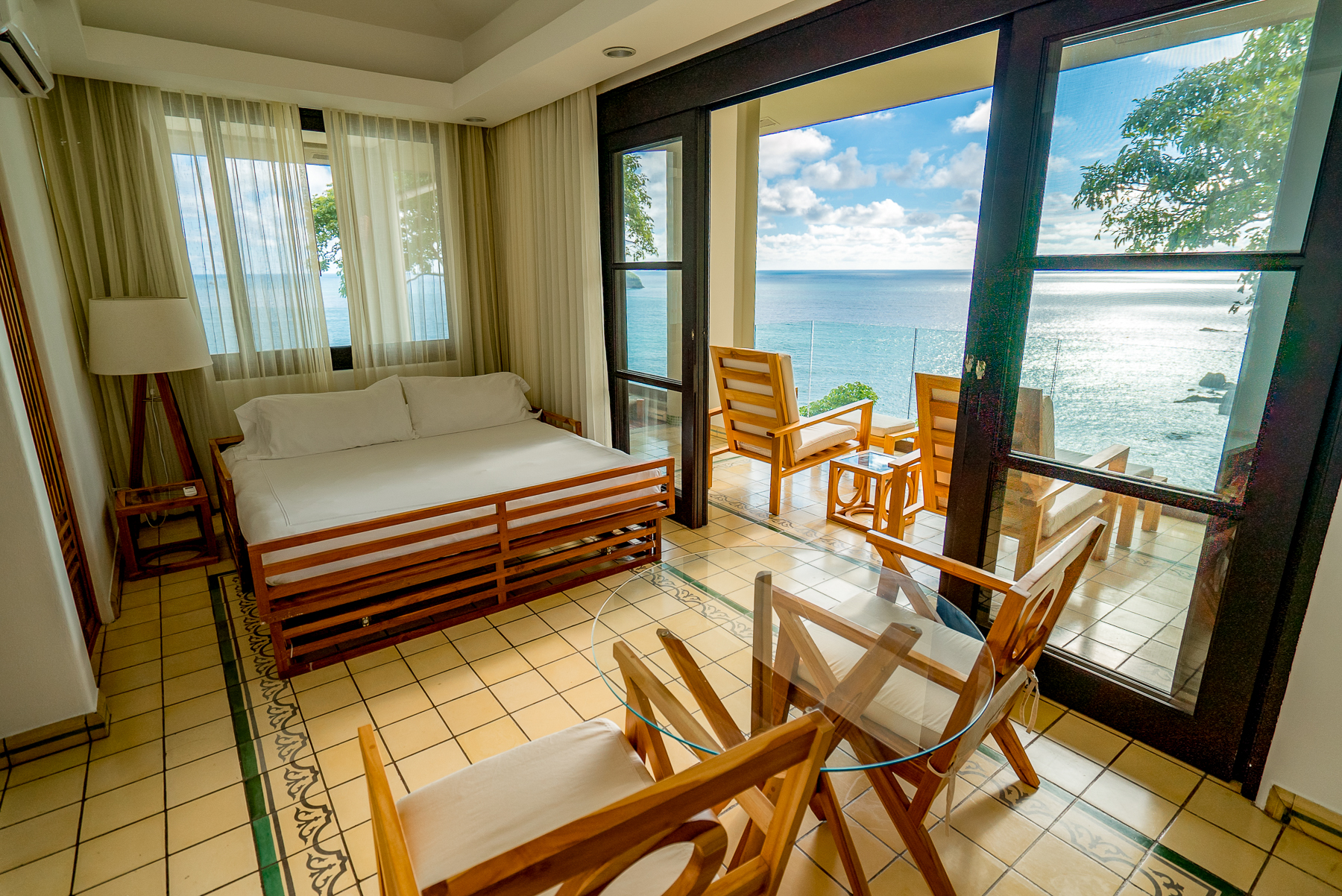 Guest suite bedroom with ocean views at Arenas del Mar in Costa Rica