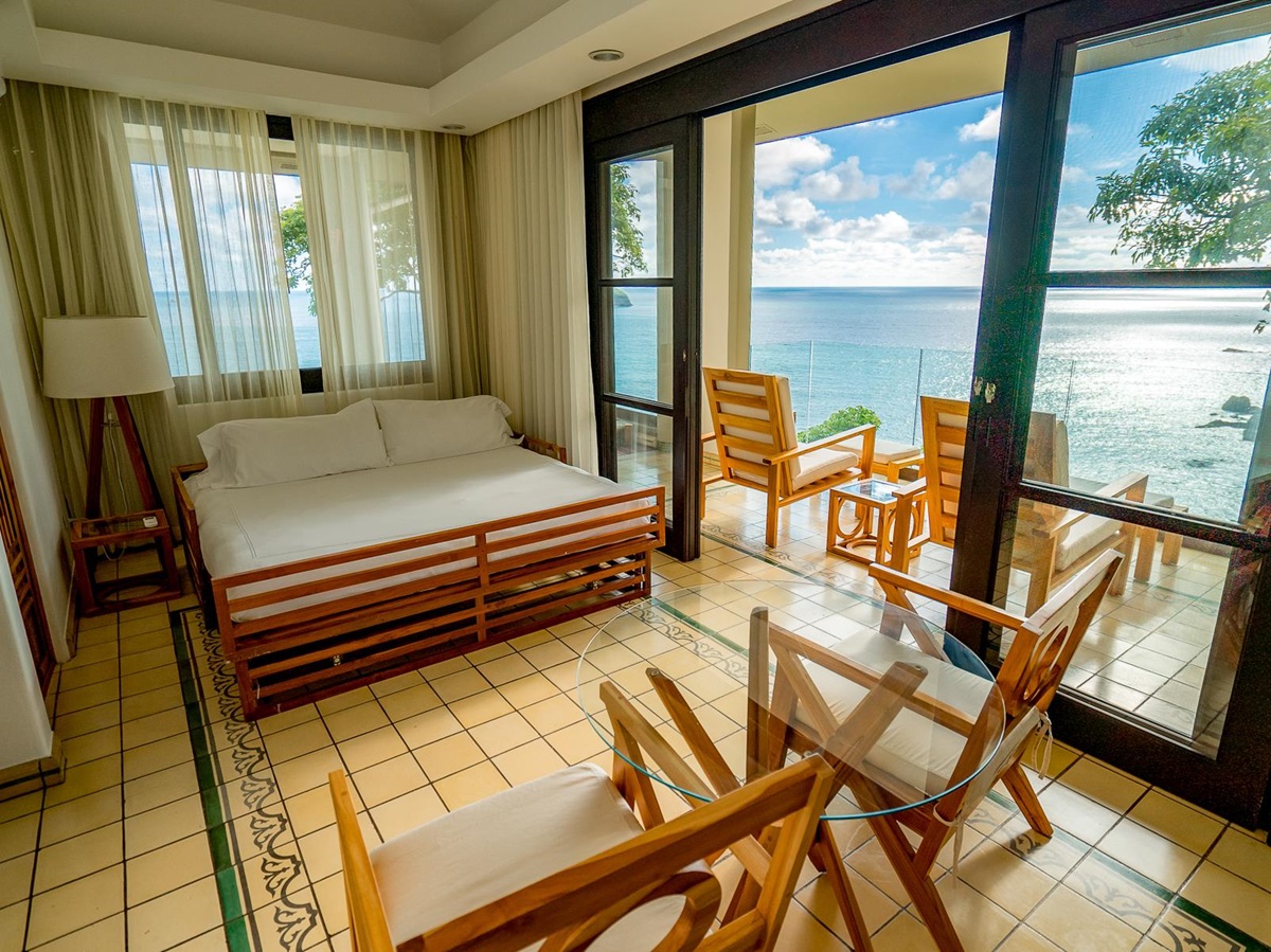 Guest suite bedroom with ocean views at Arenas del Mar in Costa Rica