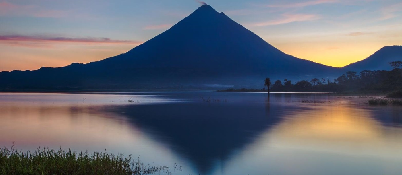 Reflection of the Arenal Volcano on Lake Arenal at sunrise