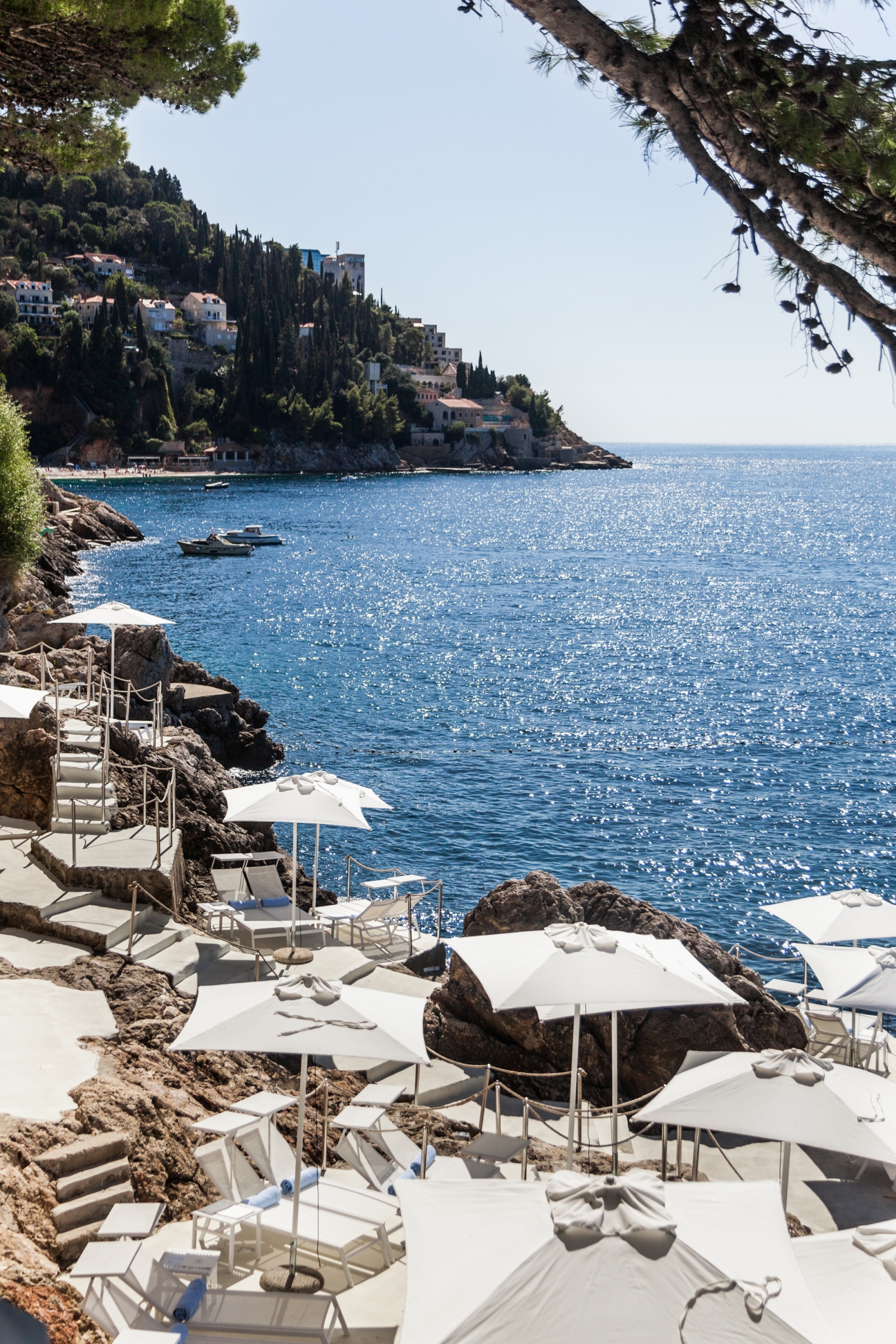 Loungers and parasols on terraces carved into the cliff at luxury hotel Villa Dubrovnik in Croatia