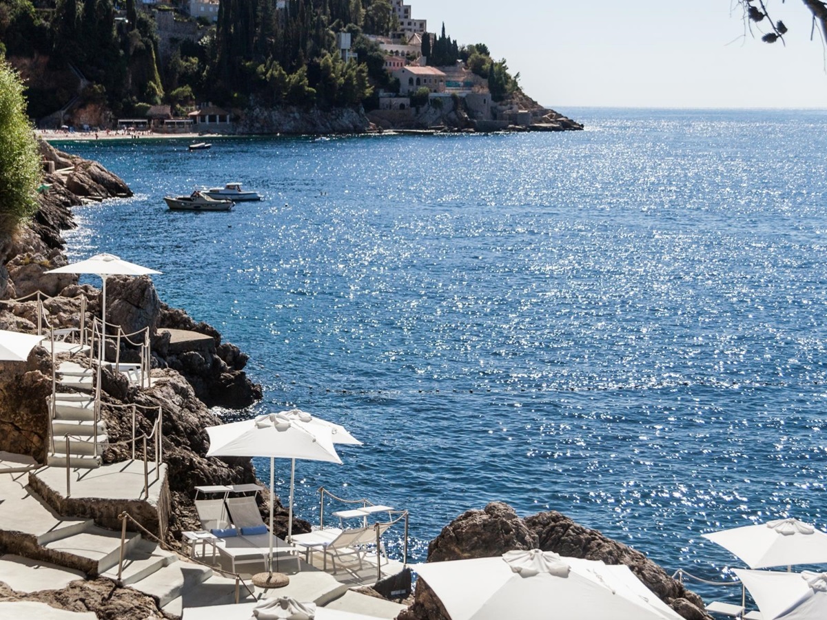 Loungers and parasols on terraces carved into the cliff at luxury hotel Villa Dubrovnik in Croatia