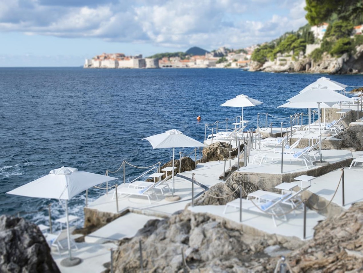 Seaside cliff with terraces for sunloungers and parasols at luxury hotel Villa Dubrovnik in Croatia
