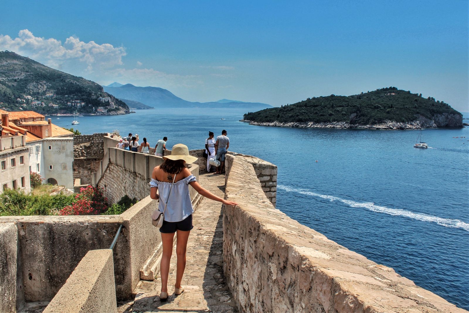 Lady walking along Dubrovnik's historic city walls with the Adriatic Sea in the background