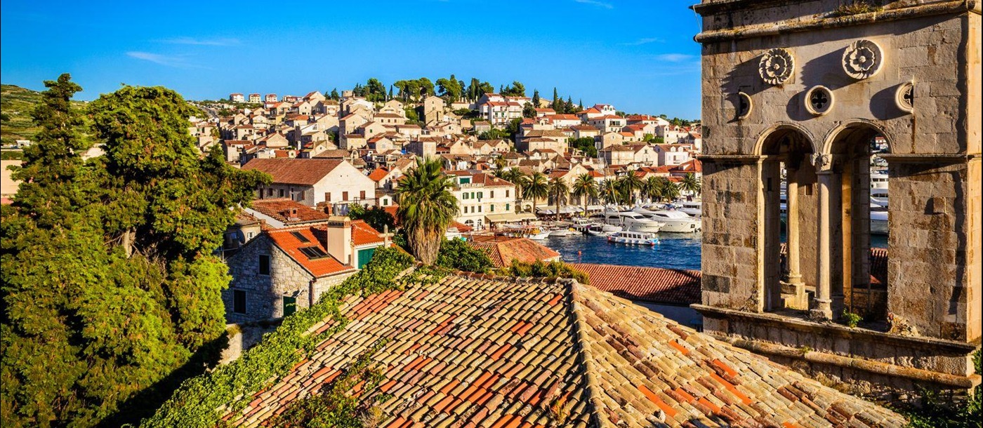 Historic church covered in ivy and the rooftops of Hvar old town in Croatia