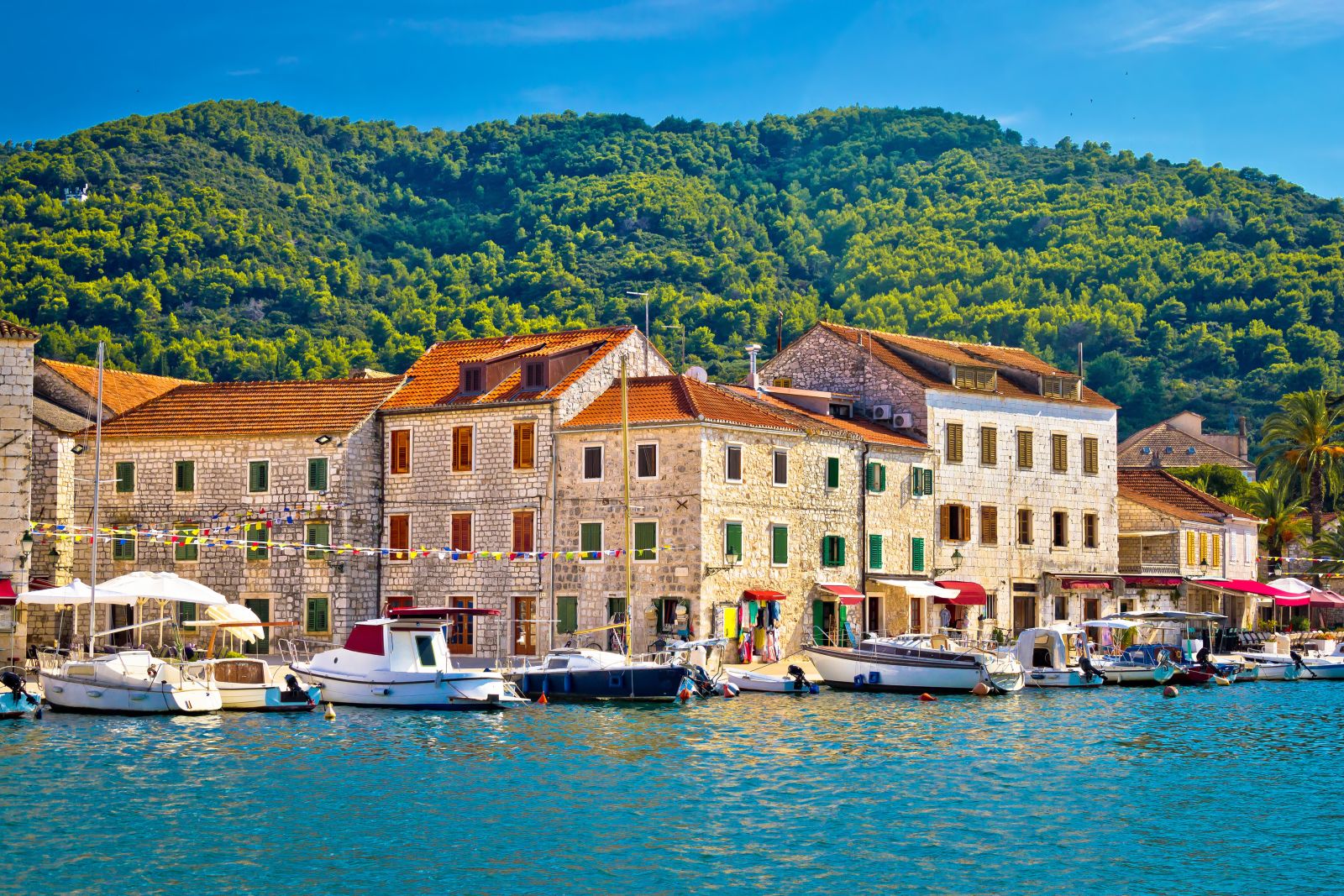 The waterfront of Hvar in Croatia with forested hills in the background