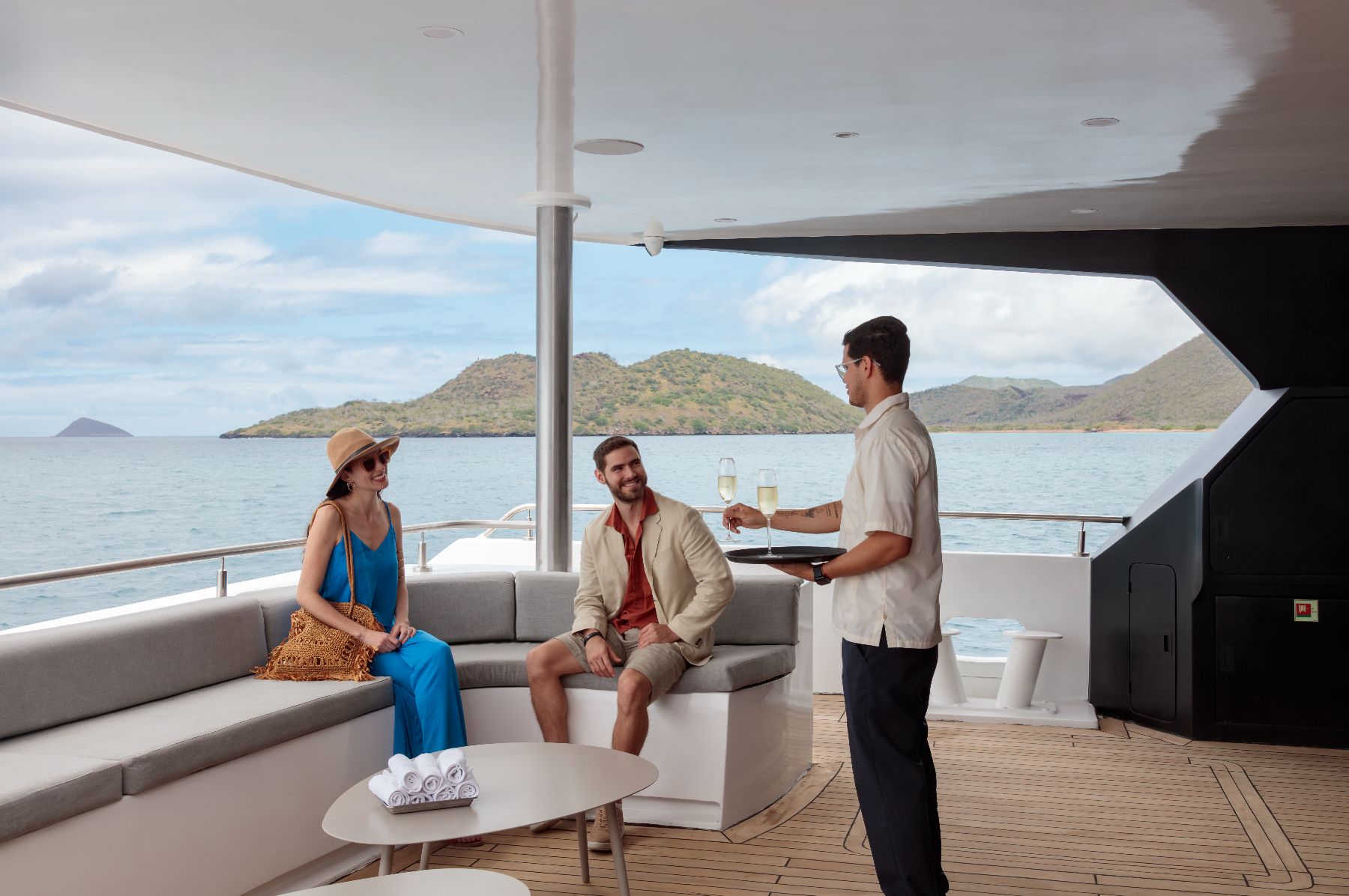 Guests enjoying champagne on the boarding deck of Hermes Galapagos luxury catamaran