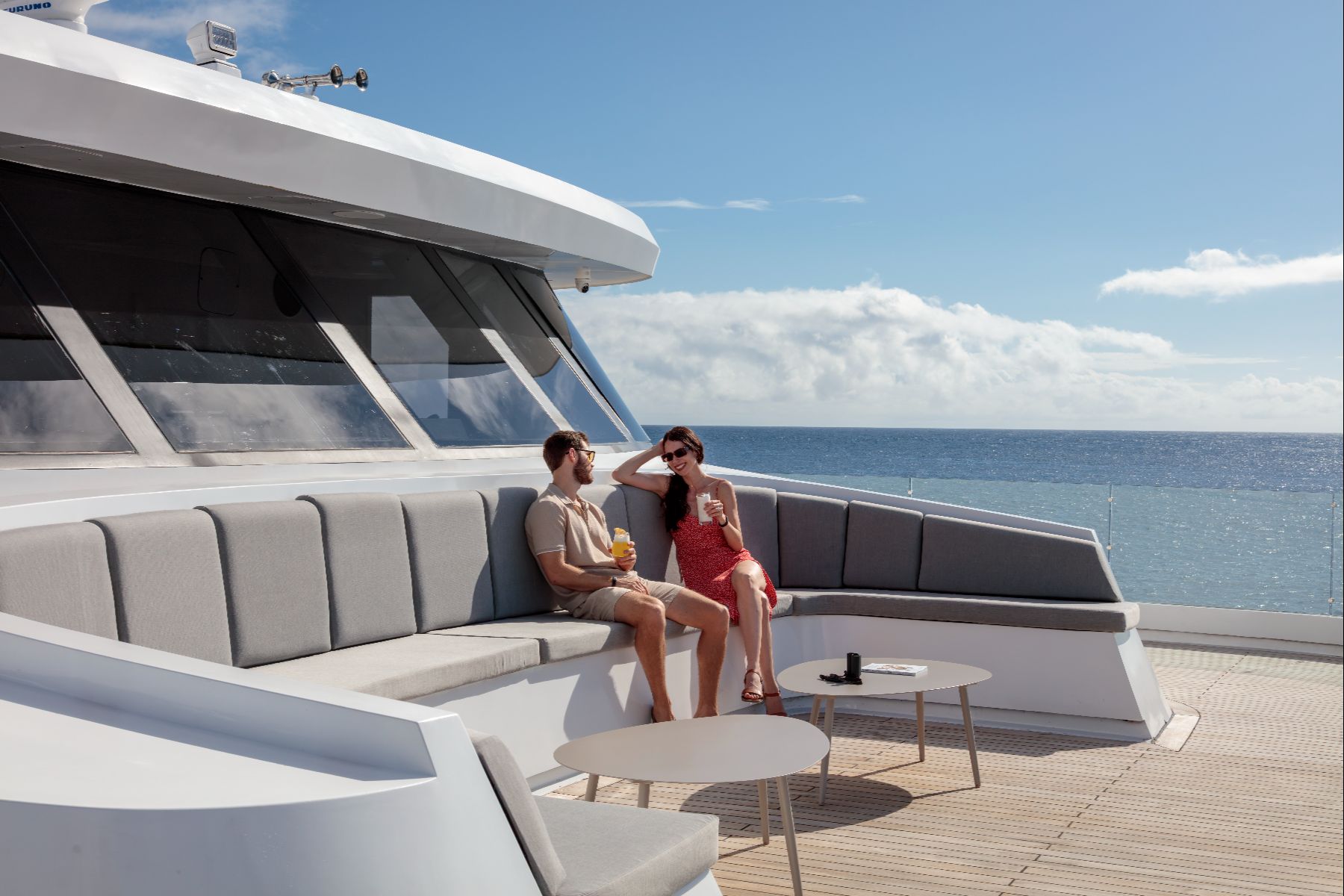 Couple enjoying drinks and Galapagos views on one of the many outdoor terraces on the Hermes Mega Catamaran
