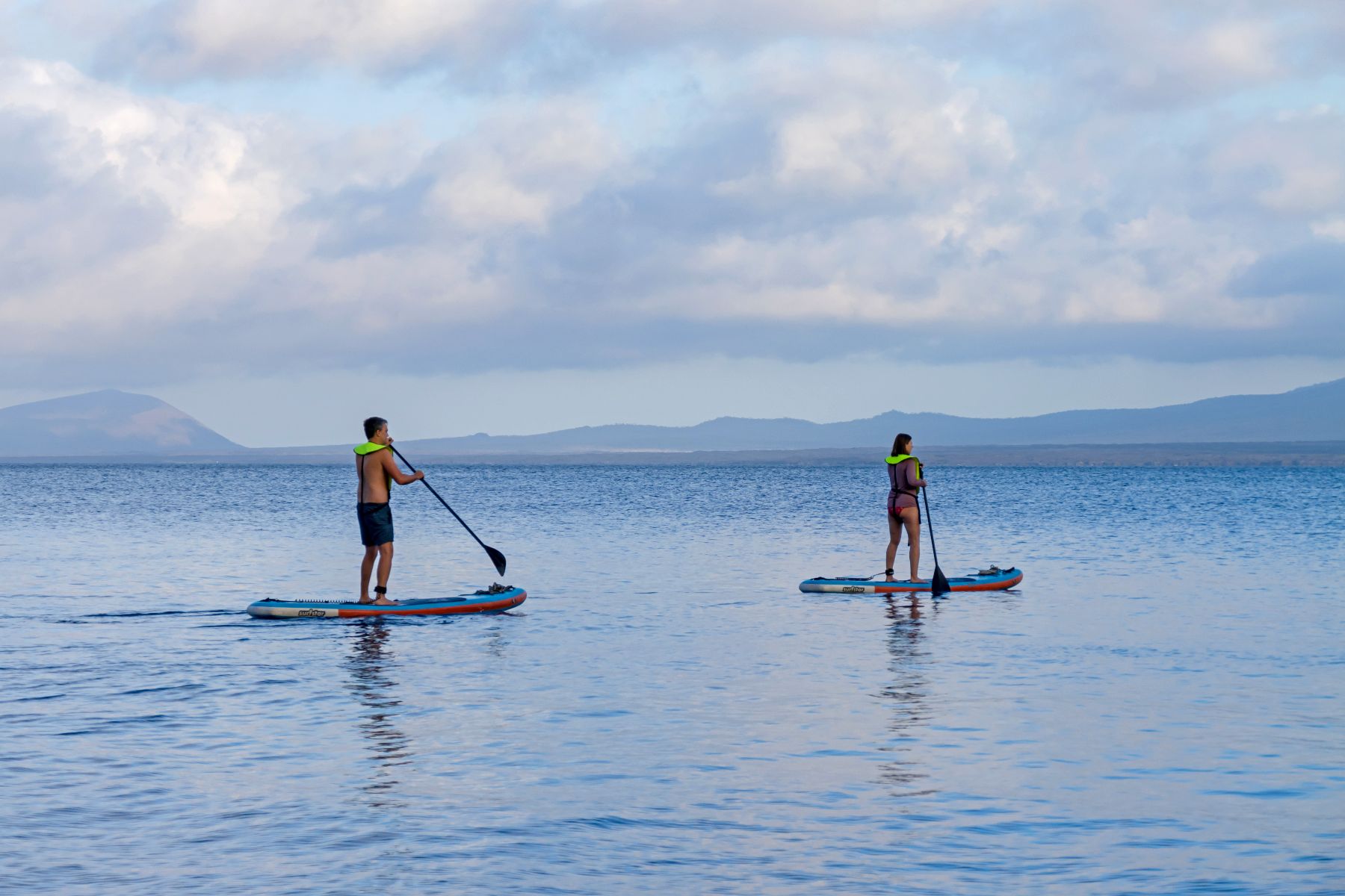 Guests of Hermes luxury catamaran on a paddle boarding activity in Galapagos