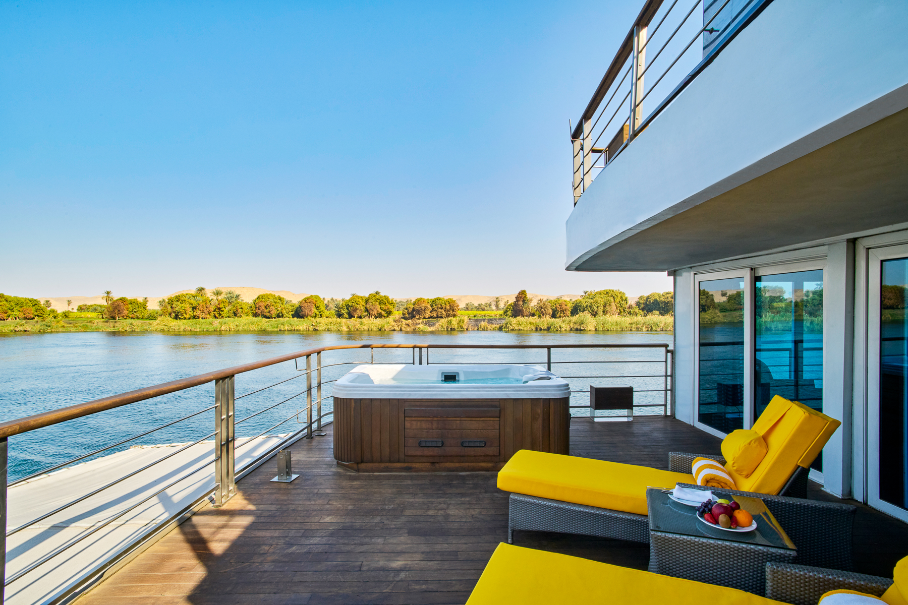Balcony with jacuzzi and yellow sun loungers onboard the Oberoi Philae luxury Nile cruiser in Egypt