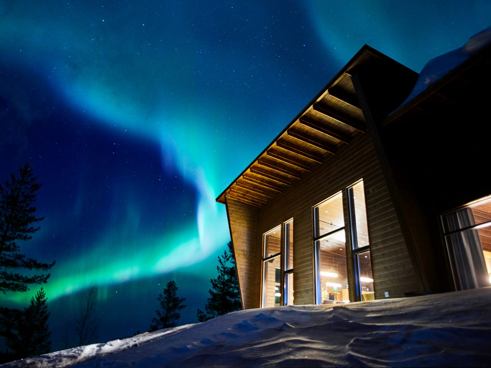 The Northern Lights shining over Octola wilderness lodge in Finland