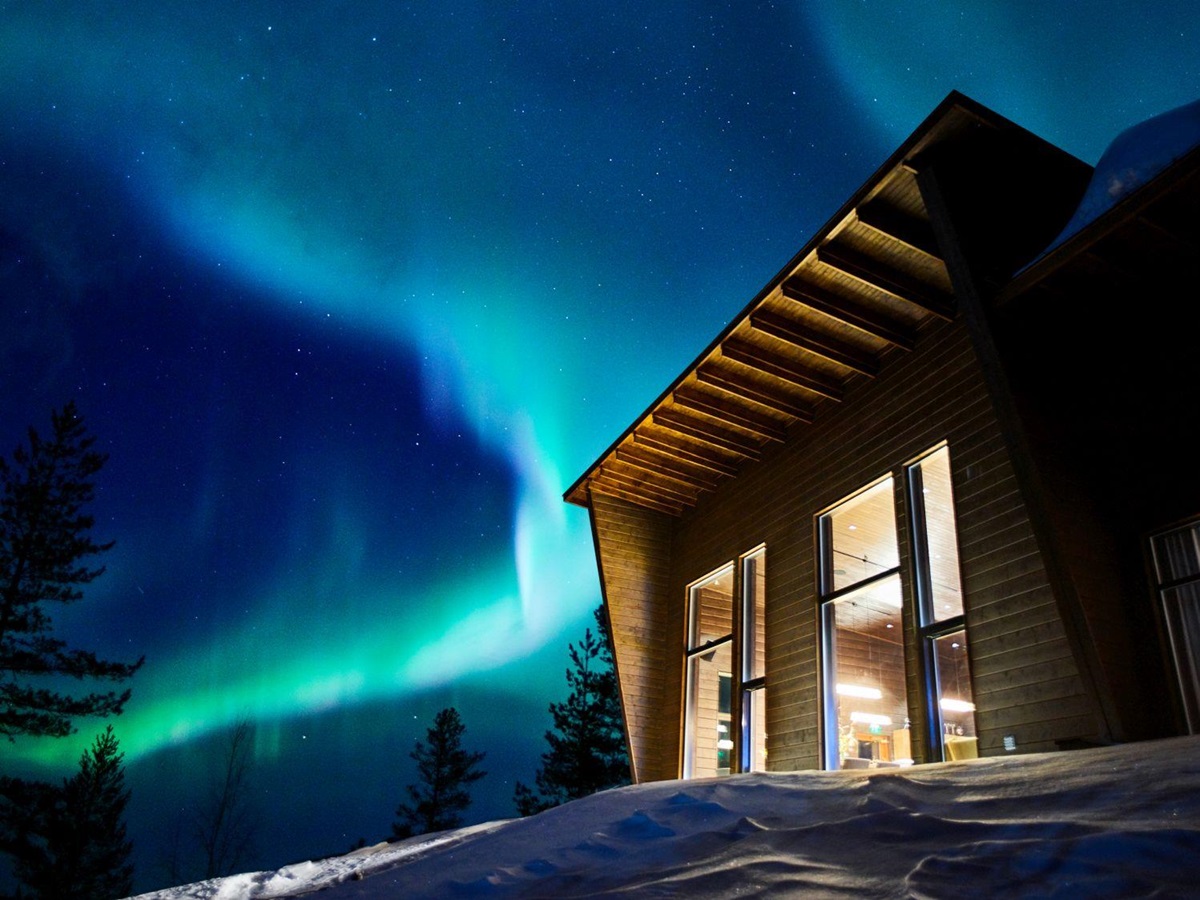 The Northern Lights shining over Octola wilderness lodge in Finland
