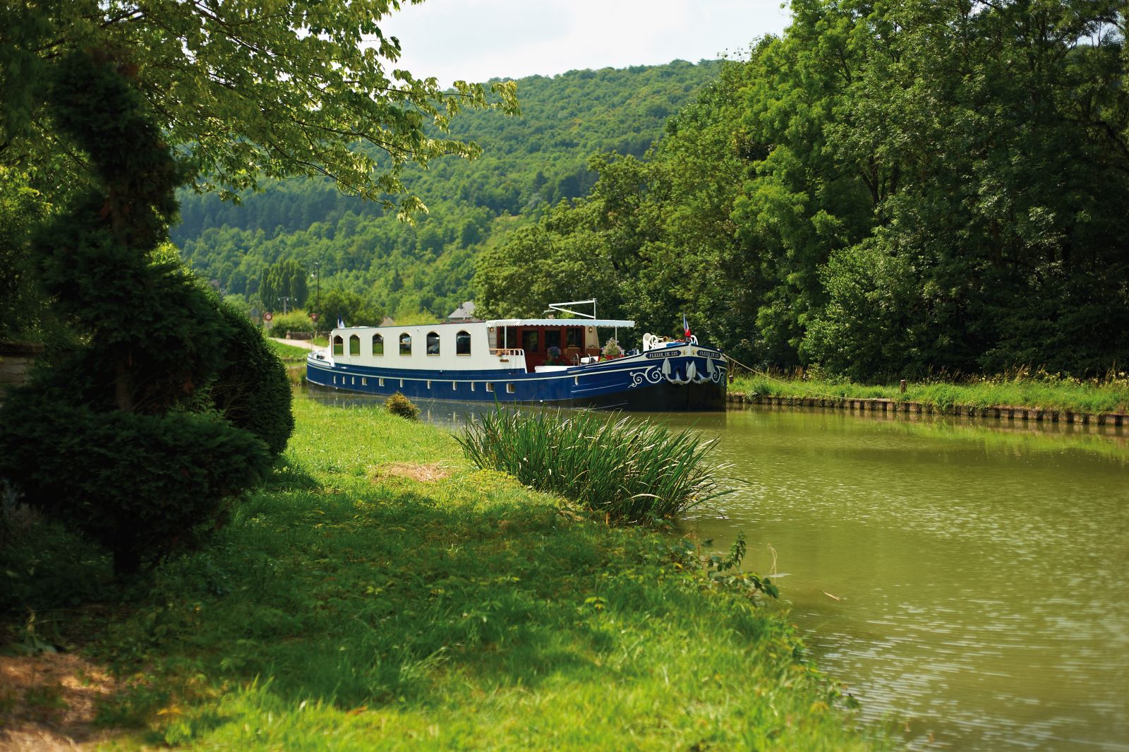 The Belmond Fleur de Lys river barge sailing through rural Burgundy in France