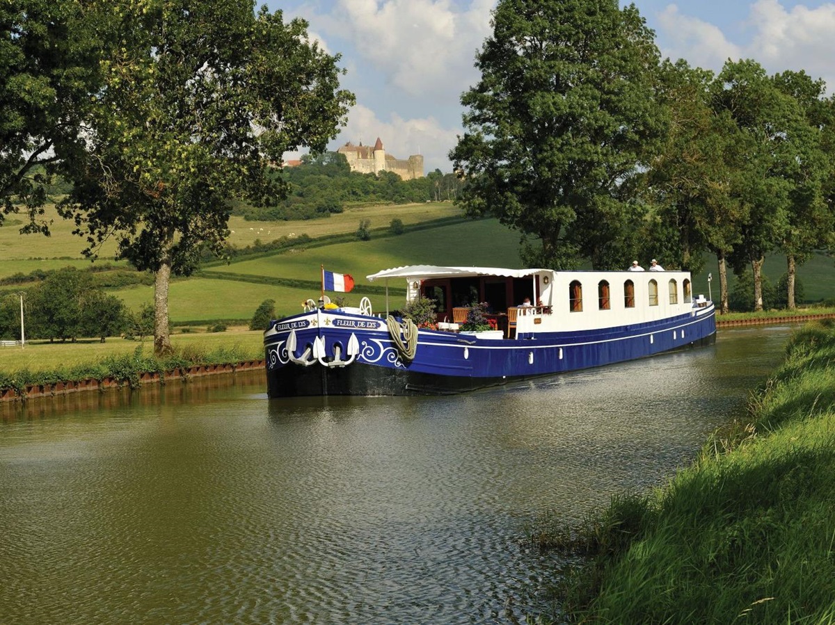 The Belmond Fleur de Lys river barge sailing through the French countryside