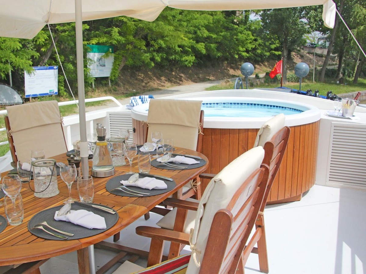 Outdoor dining and jacuzzi on board the Enchante river cruise in France