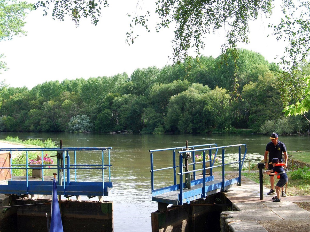 Father and child opening the locks on the Enchante canal cruise in France