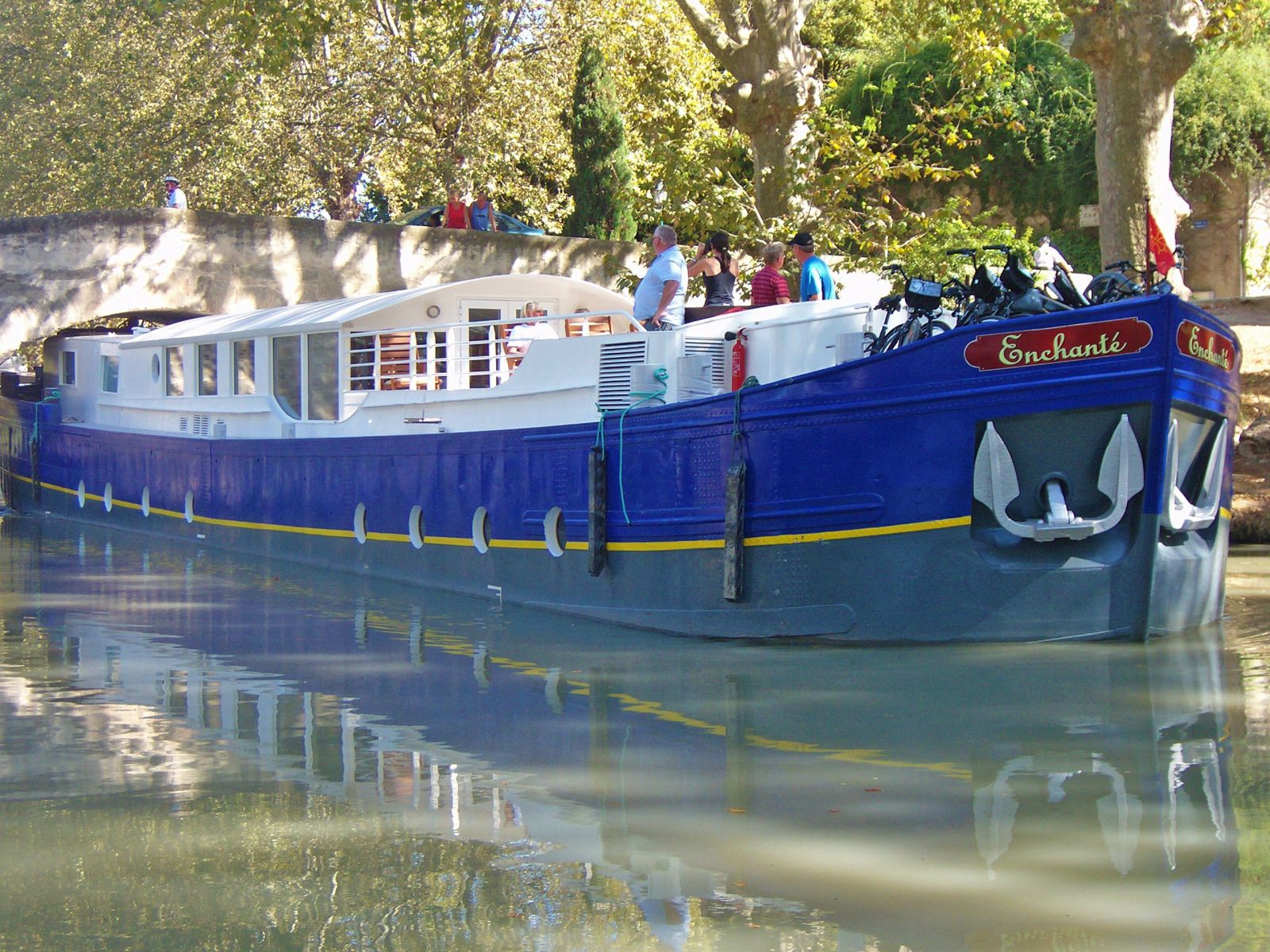 The Enchante river cruise in France passing under a bridge