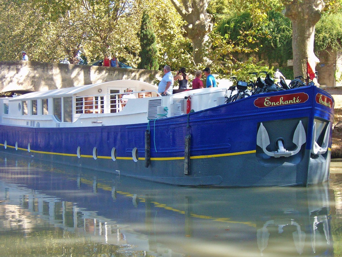 The Enchante river cruise in France passing under a bridge
