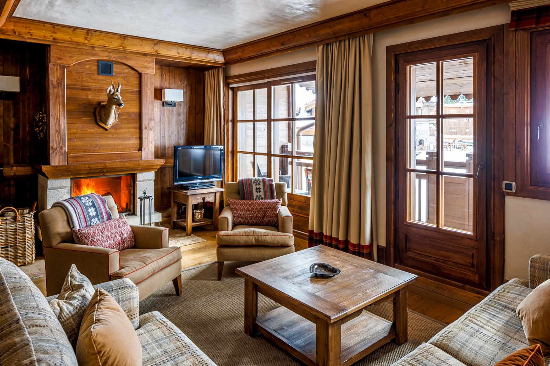 Lounge with sofas and television at Hotel Le Portetta in Courchevel