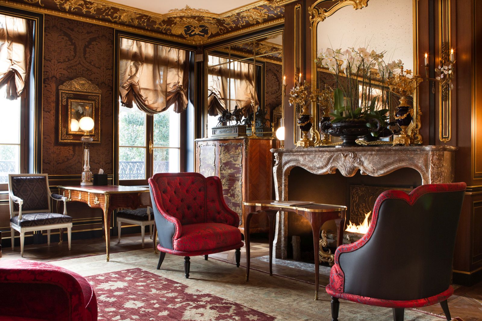 two red chairs in front of a fire at La Reserve Hotel in Paris