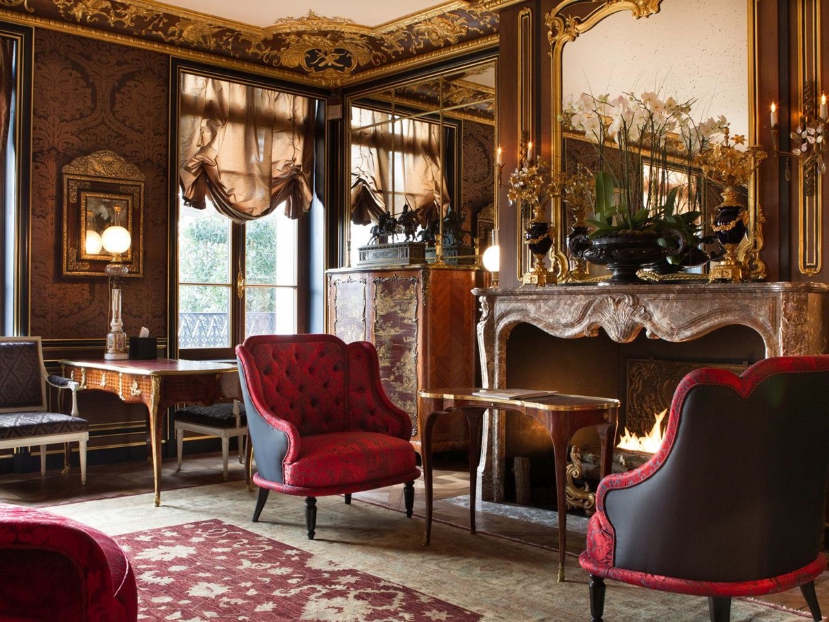 two red chsirs in front of a fire at La Reserve Hotel in Paris