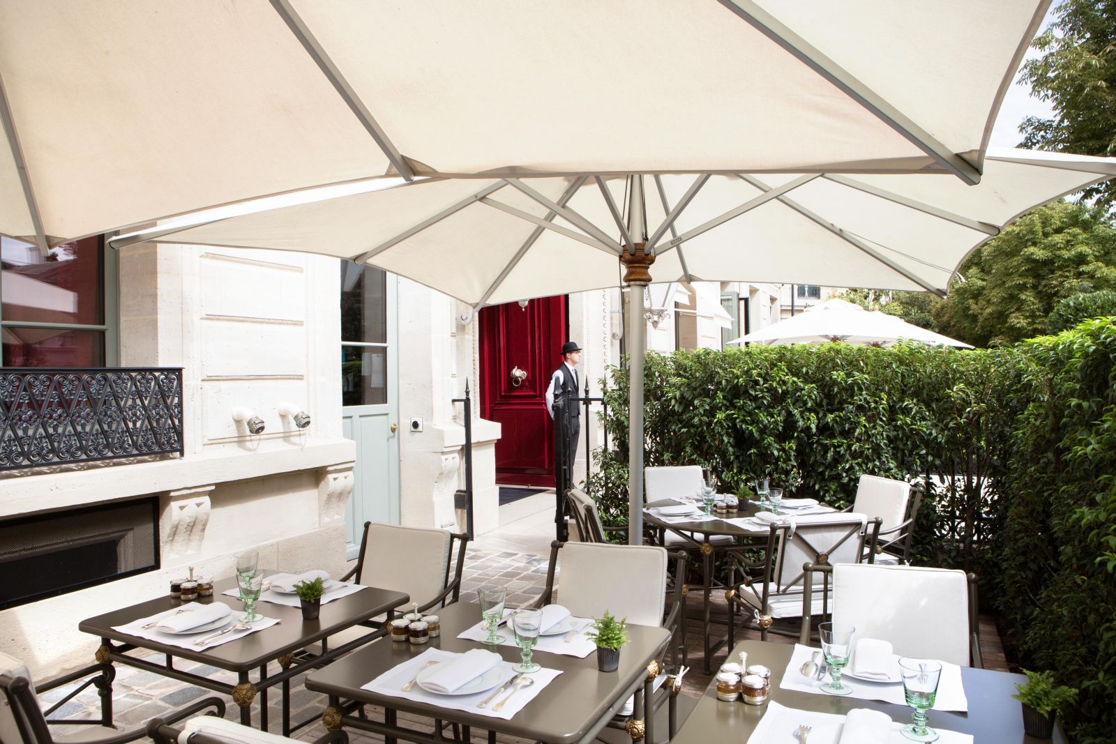 chairs and table set for lunch under a white canopy at La Reserve Hotel in Paris