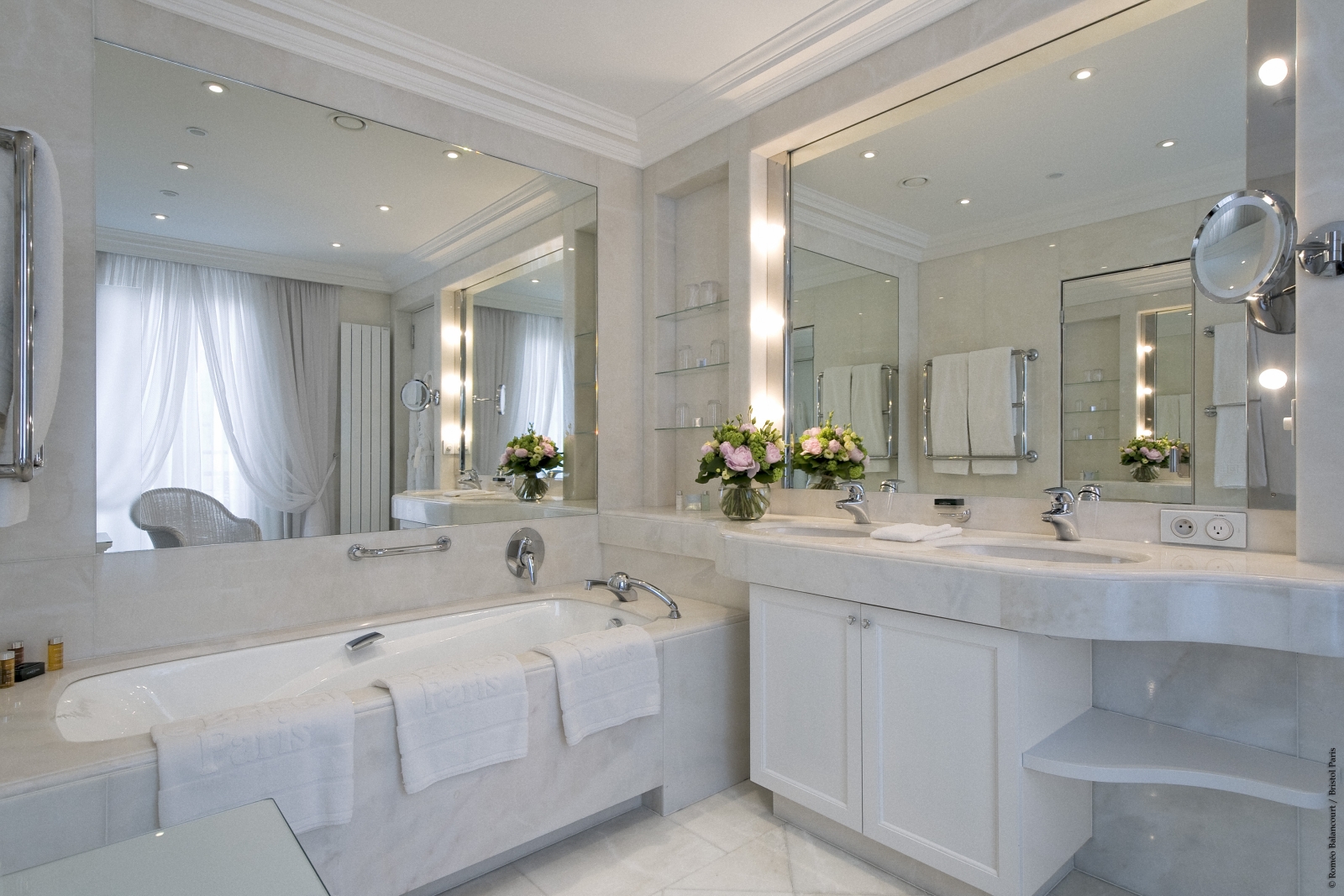 White marble en-suite bathroom with double vanity at luxury hotel Le Bristol in Paris, France