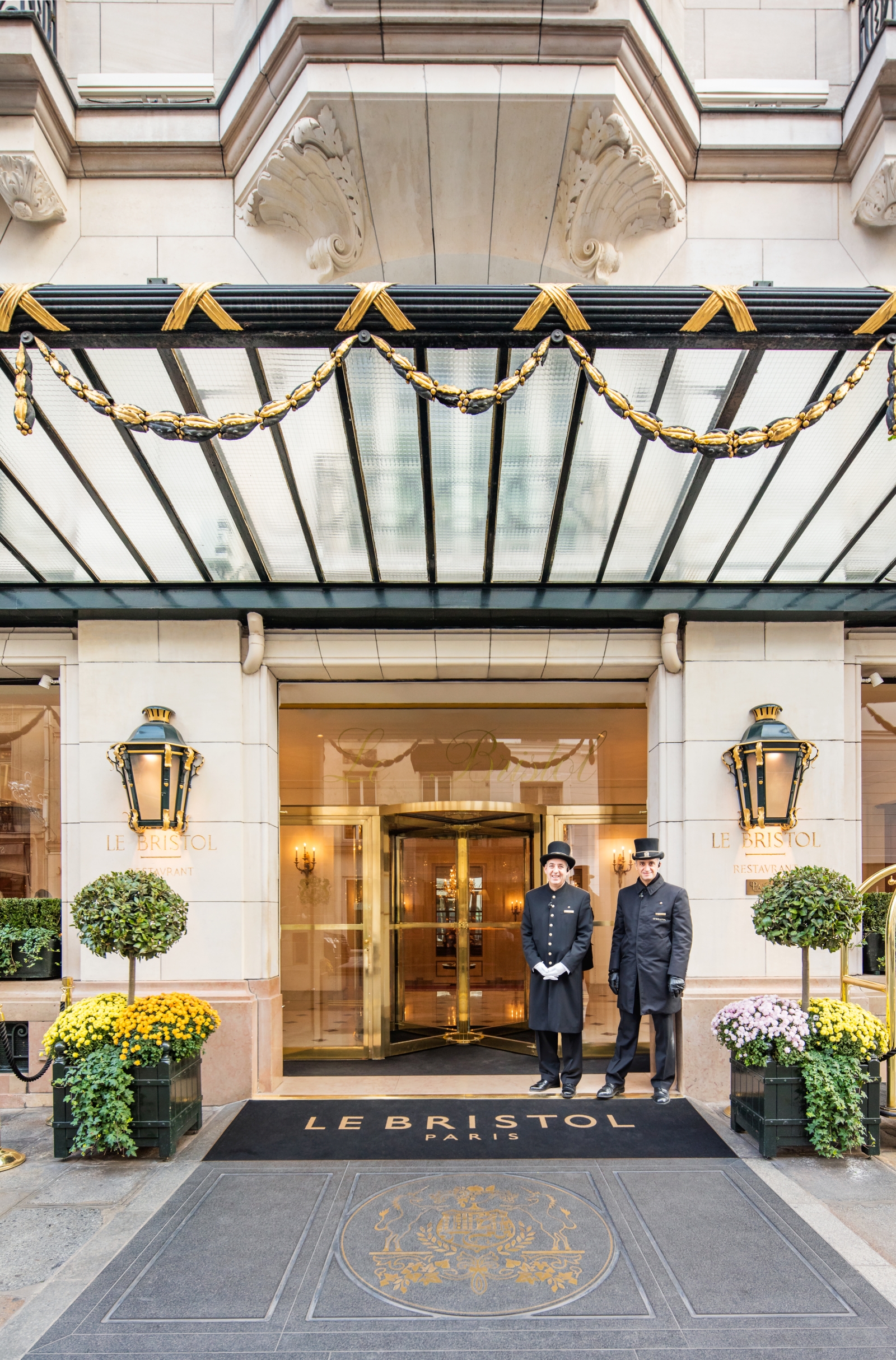 Two doormen waiting at the entrance of luxury hotel Le Bristol in Paris, France