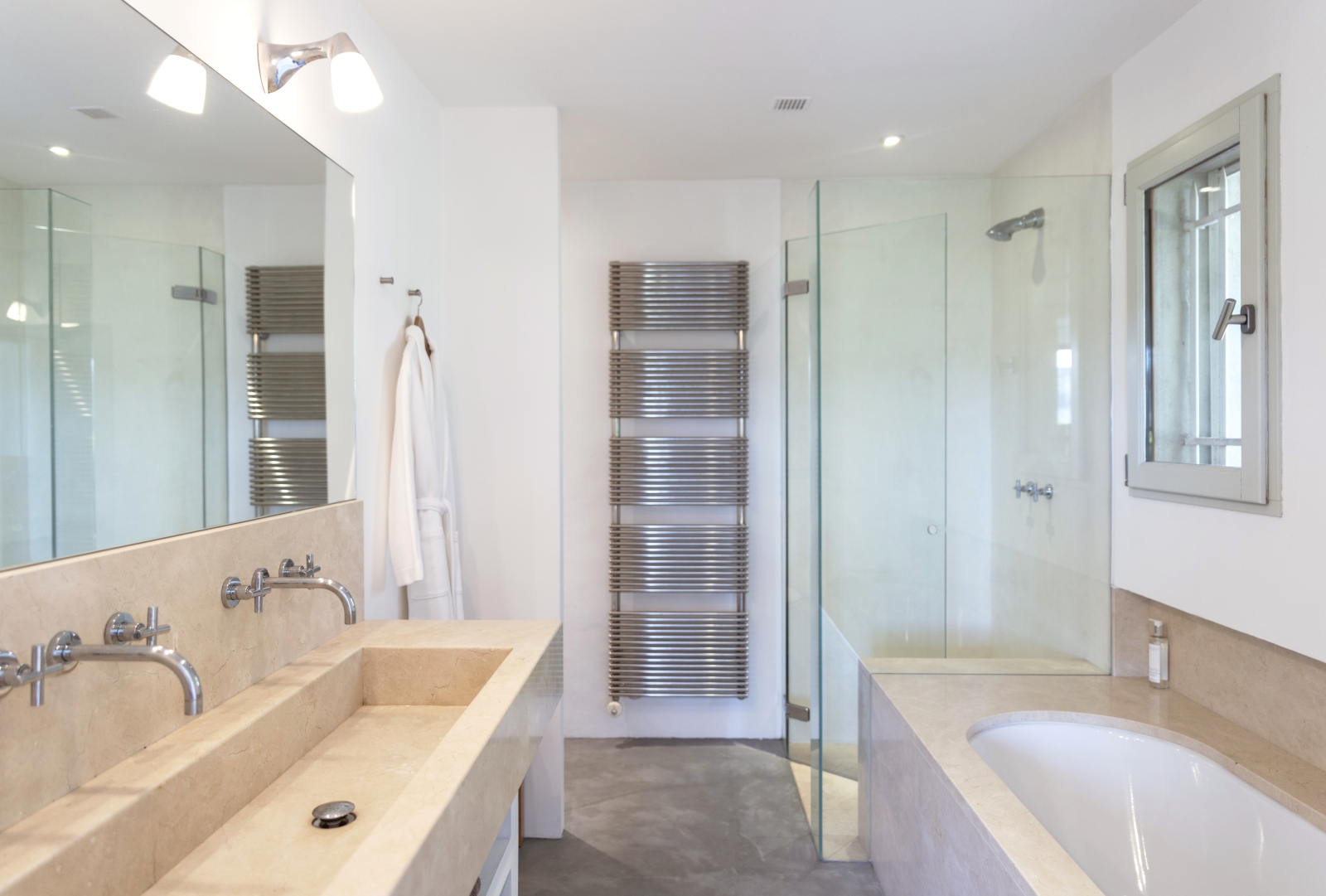 Bathroom with double sinks, bath, shower, towel rail, robe and mirror at La Cadiere on the Cote d’Azur, France