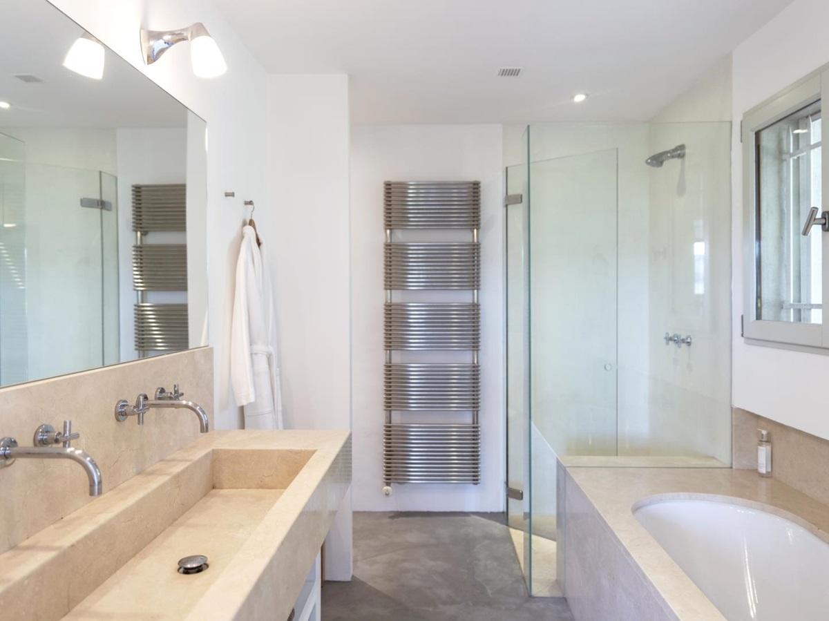 Bathroom with double sinks, bath, shower, towel rail, robe and mirror at La Cadiere on the Cote d’Azur, France