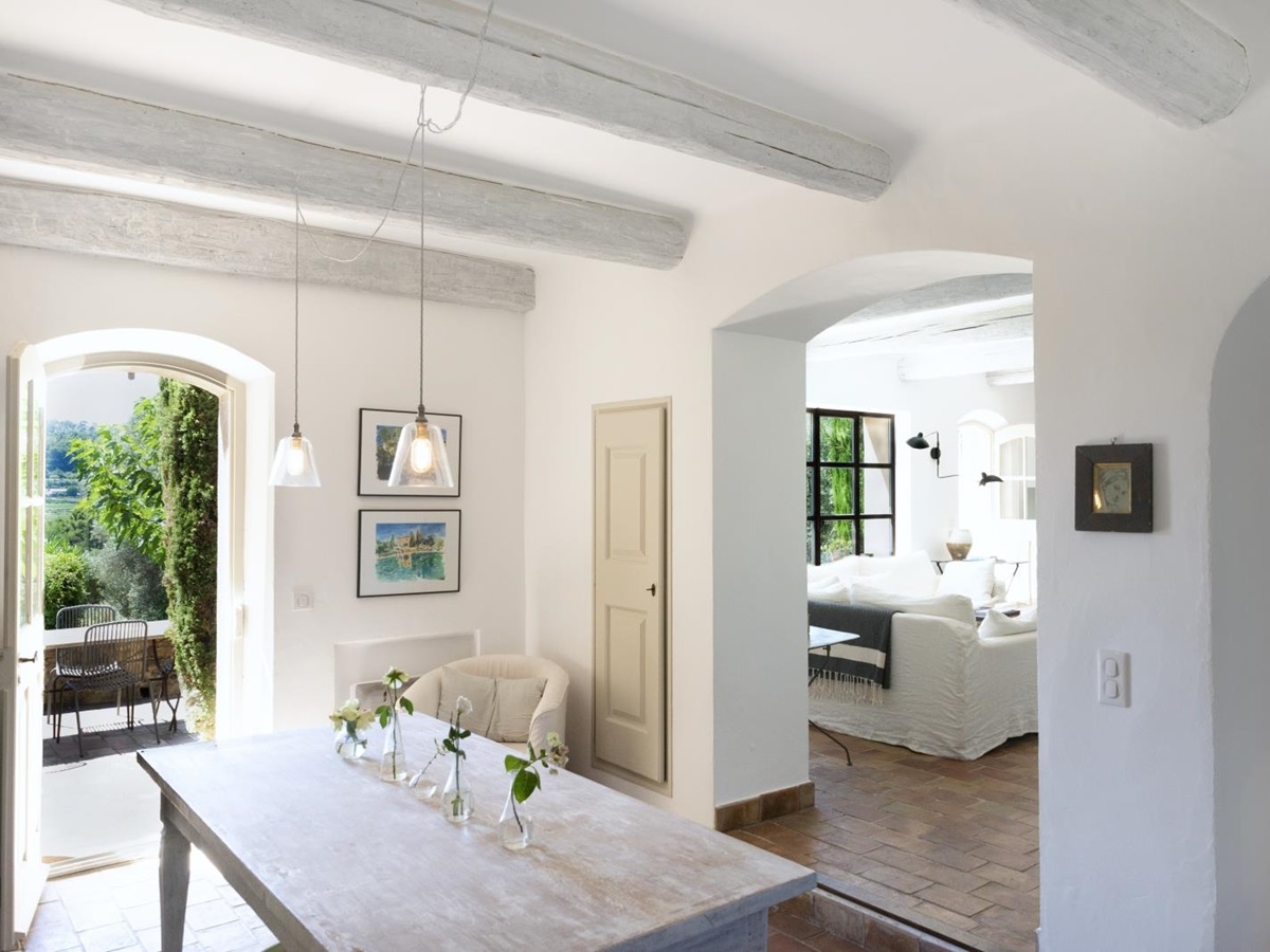 Entrance hallway with table, flowers, hanging light and archway to living room at La Cadiere on the Cote d’Azur, France