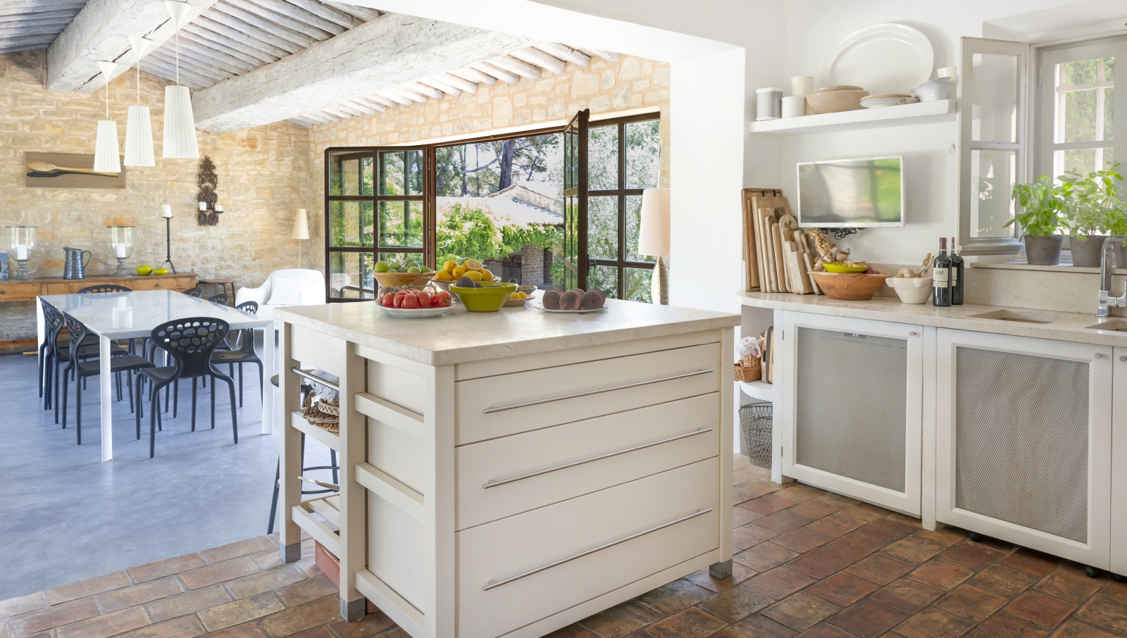 Kitchen with island, cabinets, plants, wine, TV, appliances and fresh food at La Cadiere on the Cote d’Azur, France