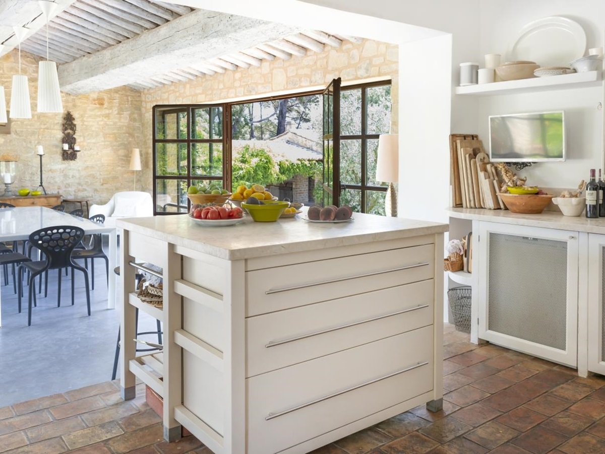 Kitchen with island, cabinets, plants, wine, TV, appliances and fresh food at La Cadiere on the Cote d’Azur, France