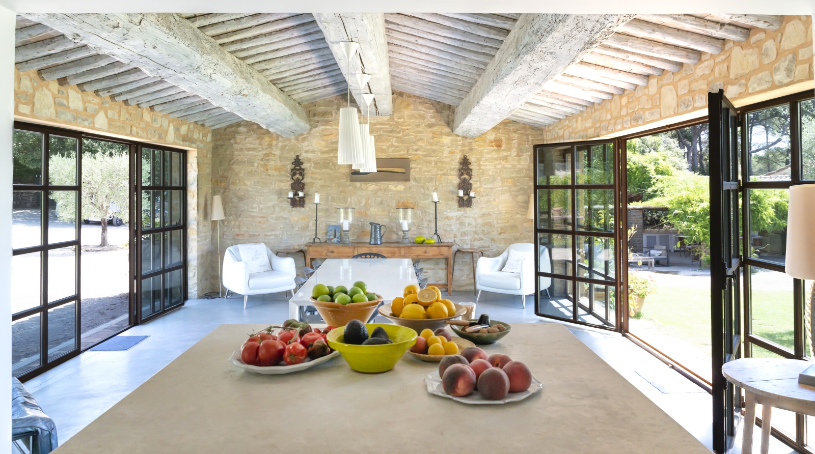 View of dining area with fresh food, armchairs, table, chairs and ceiling beams at La Cadiere on the Cote d’Azur, France