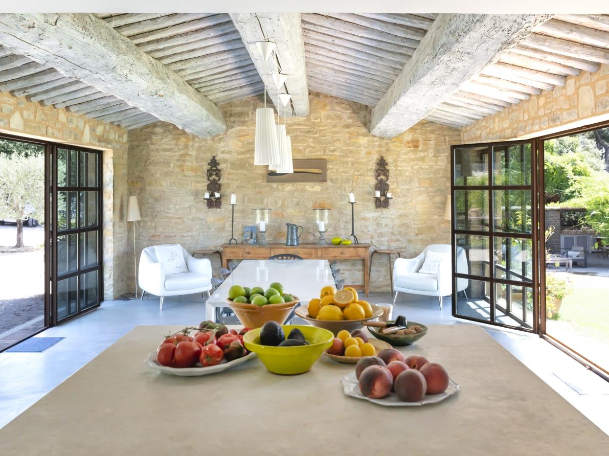 View of dining area with fresh food, armchairs, table, chairs and ceiling beams at La Cadiere on the Cote d’Azur, France