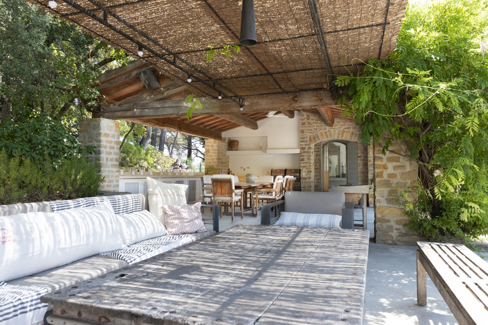 Covered outdoor lounge area with sofas, armchair, bench and table at La Cadiere on the Cote d’Azur, France