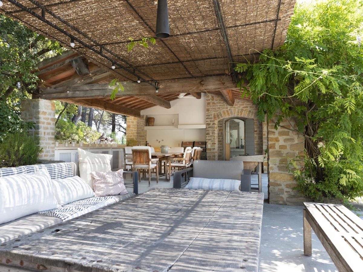 Covered outdoor lounge area with sofas, armchair, bench and table at La Cadiere on the Cote d’Azur, France