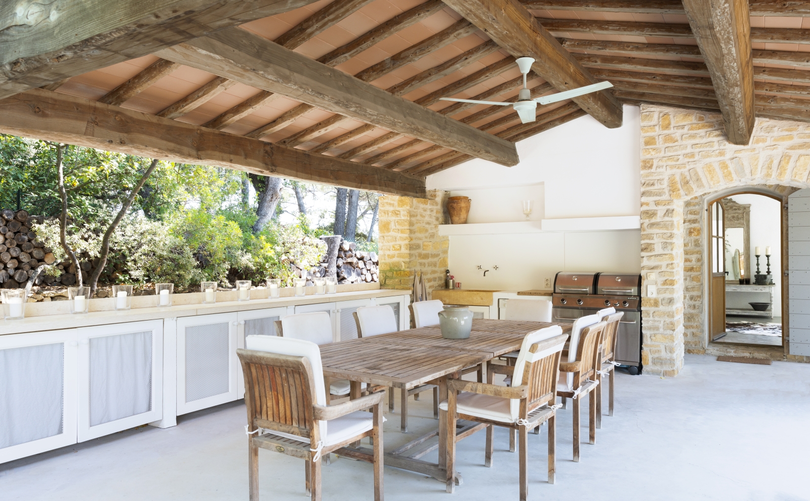 Covered outdoor dining area with table, chairs, candles, BBQ and ceiling fan at La Cadiere on the Cote d’Azur, France