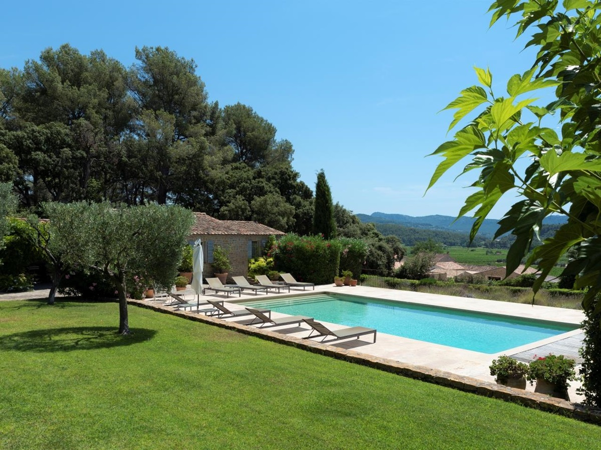Garden, pool and pool area with sun loungers, umbrellas, plants and countryside view at La Cadiere on the Cote d’Azur, France