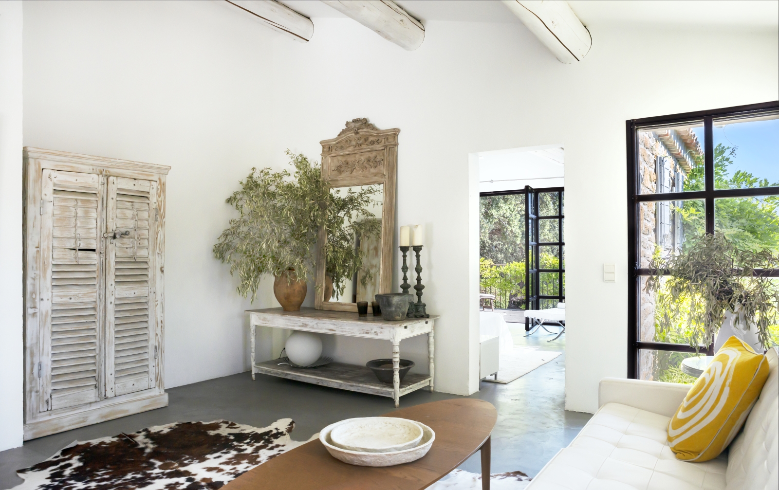 Sitting room with sofa, table, large mirror, plant and candles at La Cadiere on the Cote d’Azur, France