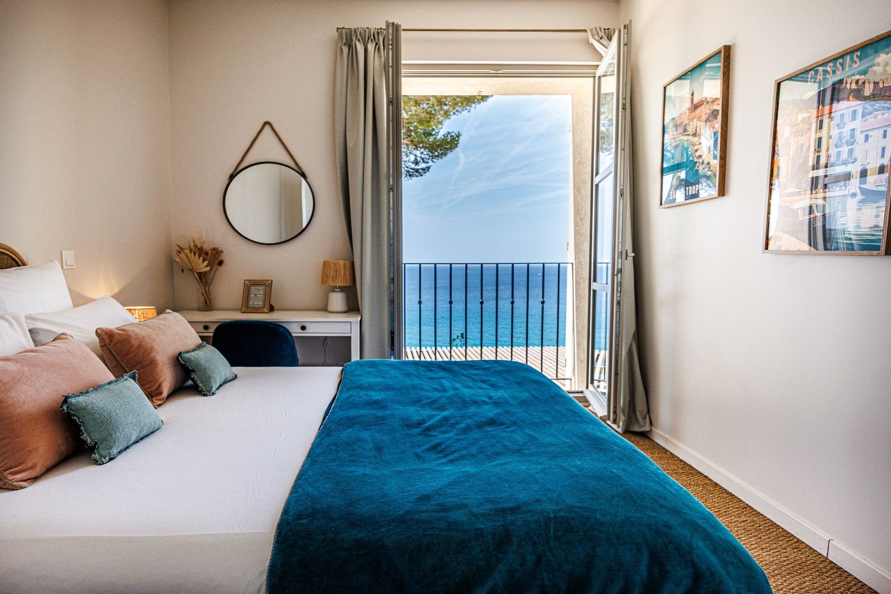 Double bedroom with teal throw and sea view at Villa Florie in Côte d'Azur